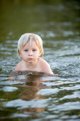 Fototapeta premium Beautiful portrait of children in lake, kids playing in the water on sunset, summer