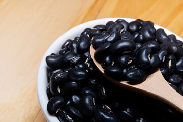 Black Beans in wooden spoon with ceramic bowl