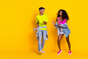 Full length body size view of attractive cheerful couple dancing enjoying free time rest isolated over bright yellow color background