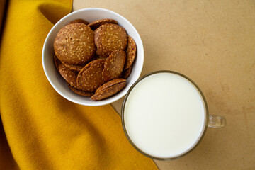 round cookies, nuts on a white plate. glass of milk
