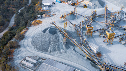Stock pile and conveyors sorting gravel at stone quarry, aerial view