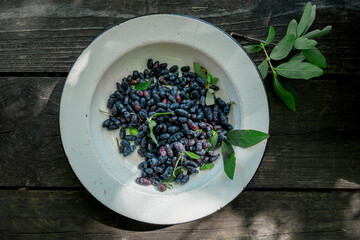 Honeysuckle berries in bowl on an old wooden surface