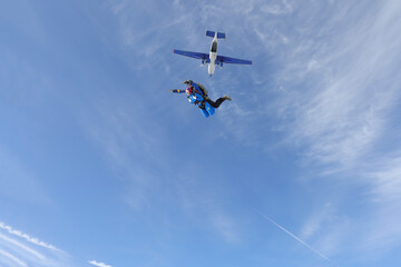 Skydiving. Tandem jump. A young woman and her instructor are in the sky. 
