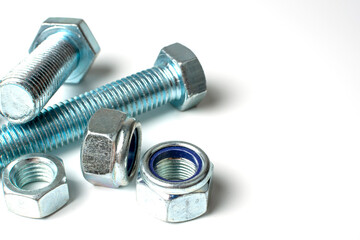 group of bolts and nuts made of light metal on a white background