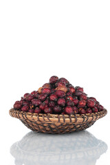Heap of dry rosehip in a wooden plate. Isolated