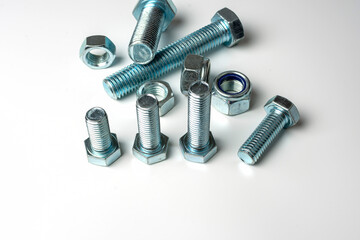 group of bolts and nuts made of light metal on a white background