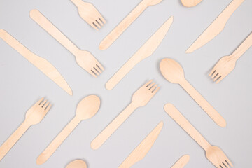 Disposable wooden cutlery set made of natural bamboo - biodegradable, compostable cultery concept on gray background, mockup image. Zero waste and environmental conservation concept. Selective focus