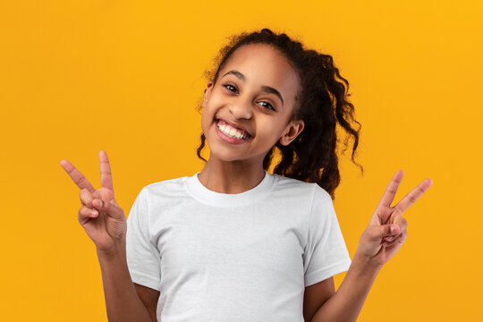 Portrait of smiling black teen girl showing peace sign