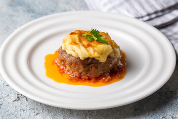 Turkish Food Hasanpasa Kofte - Kofta with Puree - Meatball with Bechamel Sauce and Green Peas. Traditional Food.