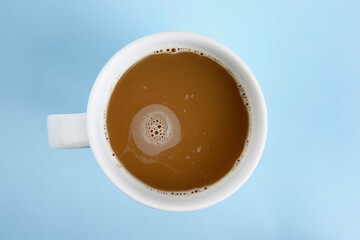 A full cup of coffee on a colored background. Coffee beans. Coffee foam.