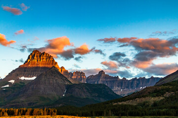 dramatic summer sunrise in Swift Current Lake in Many Glacier area in Glacier National park  with...