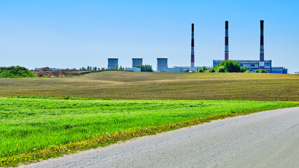 Fototapeta na wymiar thermal power plant among the fields against the blue sky