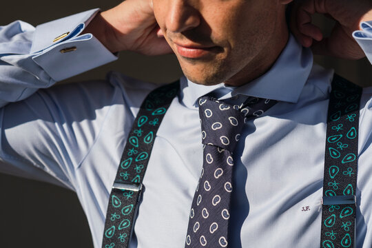 Detalles de la preparaci&oacute;n de un novio coloc&aacute;ndose la corbata