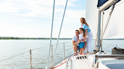 Parents And Daughter Standing On Yacht Deck On Summer Day