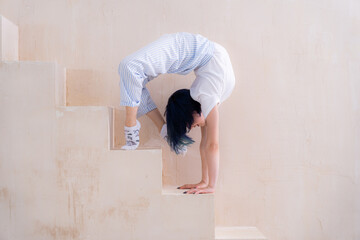 Flexible girl doing stretching in studio. Concept of individuality, creativity and yoga