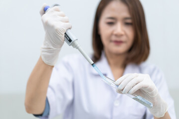 A young woman researcher, doctor, scientist, or laboratory assistant working with plastic medical...