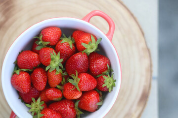 Bowl of fresh strawberries on a table. Top view.