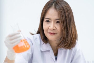 A young woman researcher, doctor, scientist, or laboratory assistant working with plastic medical tubes to research, examine scientific experiments in a modern laboratory. Education stock photo