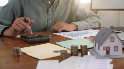 View Of coin stack with house model on green background, savings plans for housing, financial concept,Mortgage loading real estate property with loan money bank concept.Property Tax Concept