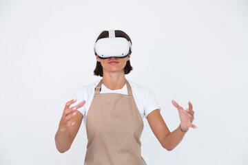 Housewife in apron isolated on white background in vr glasses cooking making dinner play games