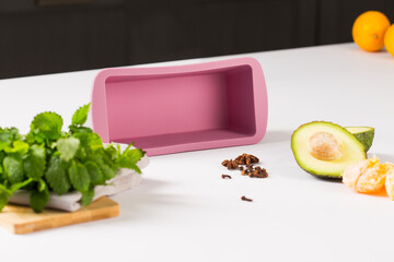 purple rectangular silicone mold in the form of baking chocolate cake, next to fruits and greens...