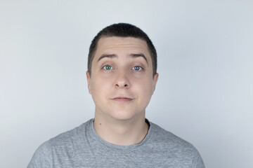 A man with different color eyes looks into the frame. The right eye is blue and the left is green. Heterochromia. Gene mutation. Multi-colored eyes.