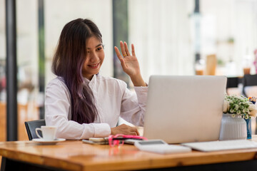 Portrait of asian young Businesswoman doing finances,accounting analysis,report,data and pointing graph at the coffee shop.
