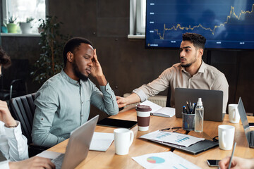 Sick young black male worker suffering from headache