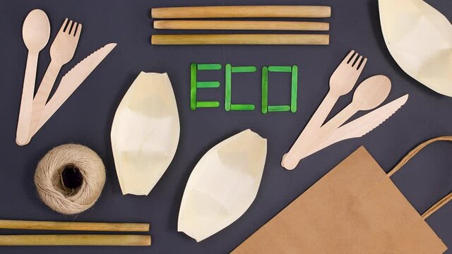 Eco friendly bamboo cutlery eating utensil ordering on black background. Stop motion 