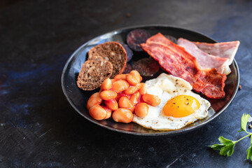 english breakfast fried egg fresh black pudding blood sausage, cereal bread, beans, bacon, scrambled eggs healthy meal snack copy space food background rustic 