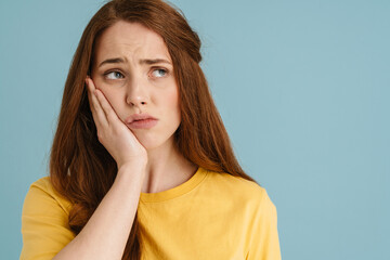 Young ginger white woman with toothache looking aside