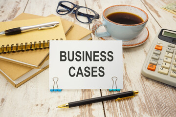 A sign with the inscription BUSINESS CASES on the table with coffee and notebooks