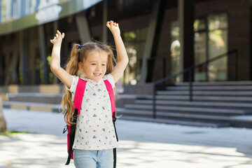 Happy little girl with backpack is going to school.