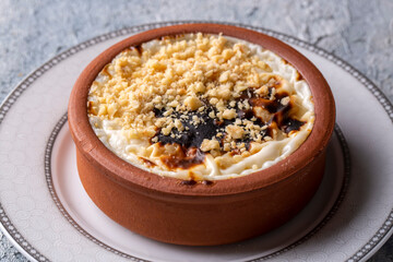 Baked rice pudding turkish milky dessert sutlac in earthenware casserole with hazelnuts