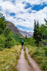 A kid riding on his father's shoulders during a hike in the outdoors in Glacier national Park in Montana.
