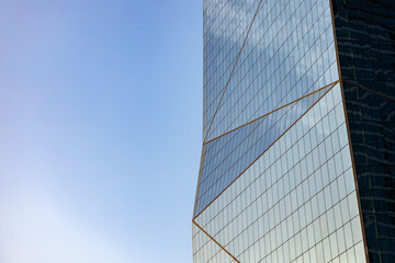 Plakat Glass skyscraper against blue sky, view from bottom