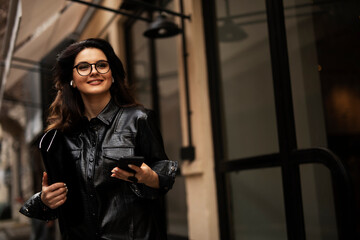 Obraz premium Young smiling woman enjoying outdoors. Beautiful woman using the phone while walking in the morning...