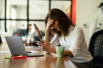 Portrait of tired businesswoman. Sad exhausted woman working on laptop in the office.