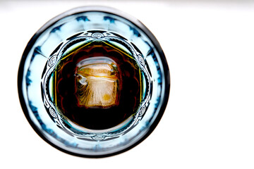 Blue glass with alcoholic cocktail with ice
on white background. Summer rest. Celebrate and enjoy the moment. Tasting of alcoholic beverages. Romantic evening aperitif. Close-up glass of wine