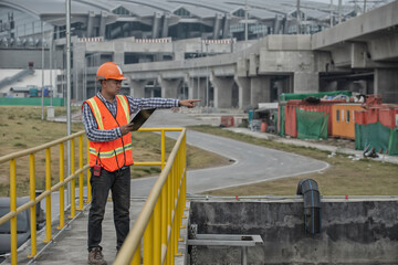 Naklejka premium construction worker on construction site. Worker taking note using pen and paper. male engineer checks equipment at work and records readings.