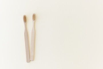 Eco-friendly bamboo toothbrushes on a beige background. Natural organic bathroom beauty product concept. Flat lay, top view, copy space