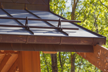 Close up view of fastening metal snow retainer on copper roof
