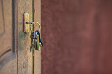 The door lock with the handle and a key. Opening a wooden door with a chrome key. Forgot door key at home. Copy space. Space for text.