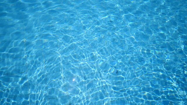 Pure shining and calming light blue waters Impressive background from rippling, surging up and down in a swimming pool outdoors in summer