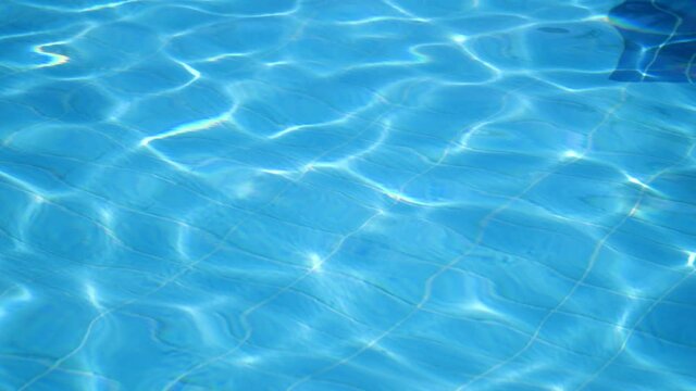 Pure shining and calming light blue waters Impressive background from rippling, surging up and down in a swimming pool outdoors in summer