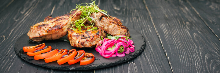 beef steak with spices and vegetables, on a wooden table