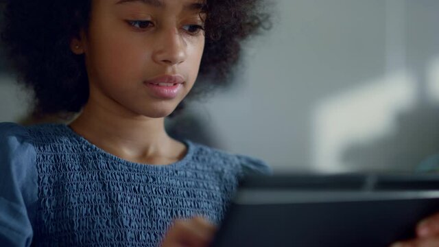 Student holding digital tablet in hands. Girl learning online on tablet computer