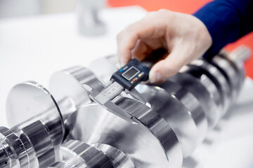 Closeup checks dimensions with vernier caliper at finish detail after metalworking on cnc machine...