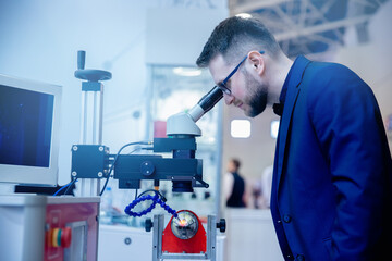 Industrial worker use microscope for precision plasma welding at modern factory floor