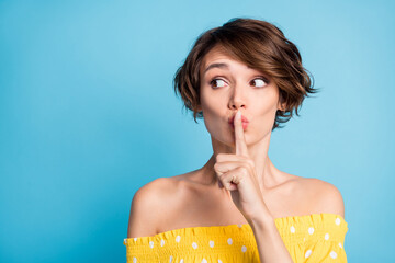 Photo of scared young amazed woman hold finger lips silence look empty space isolated on blue color...